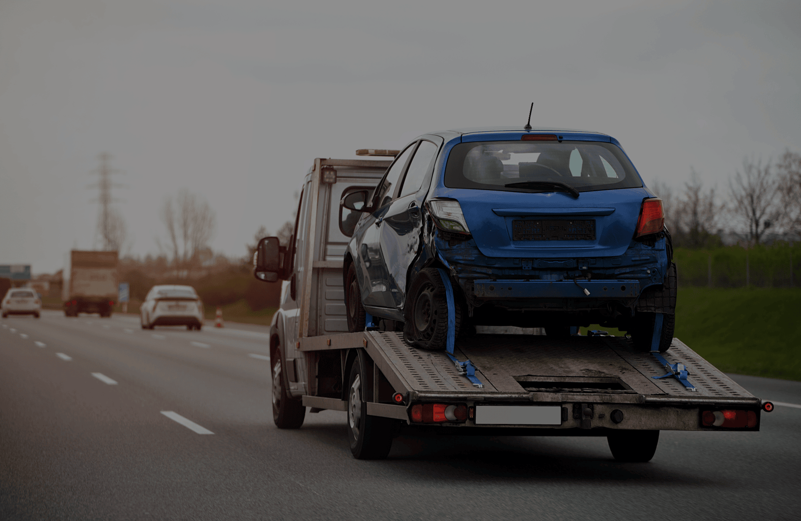 blue-car-trailer-is-being-towed-by-towing